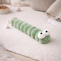 Plush caterpillar toy on a light surface with a neutral background