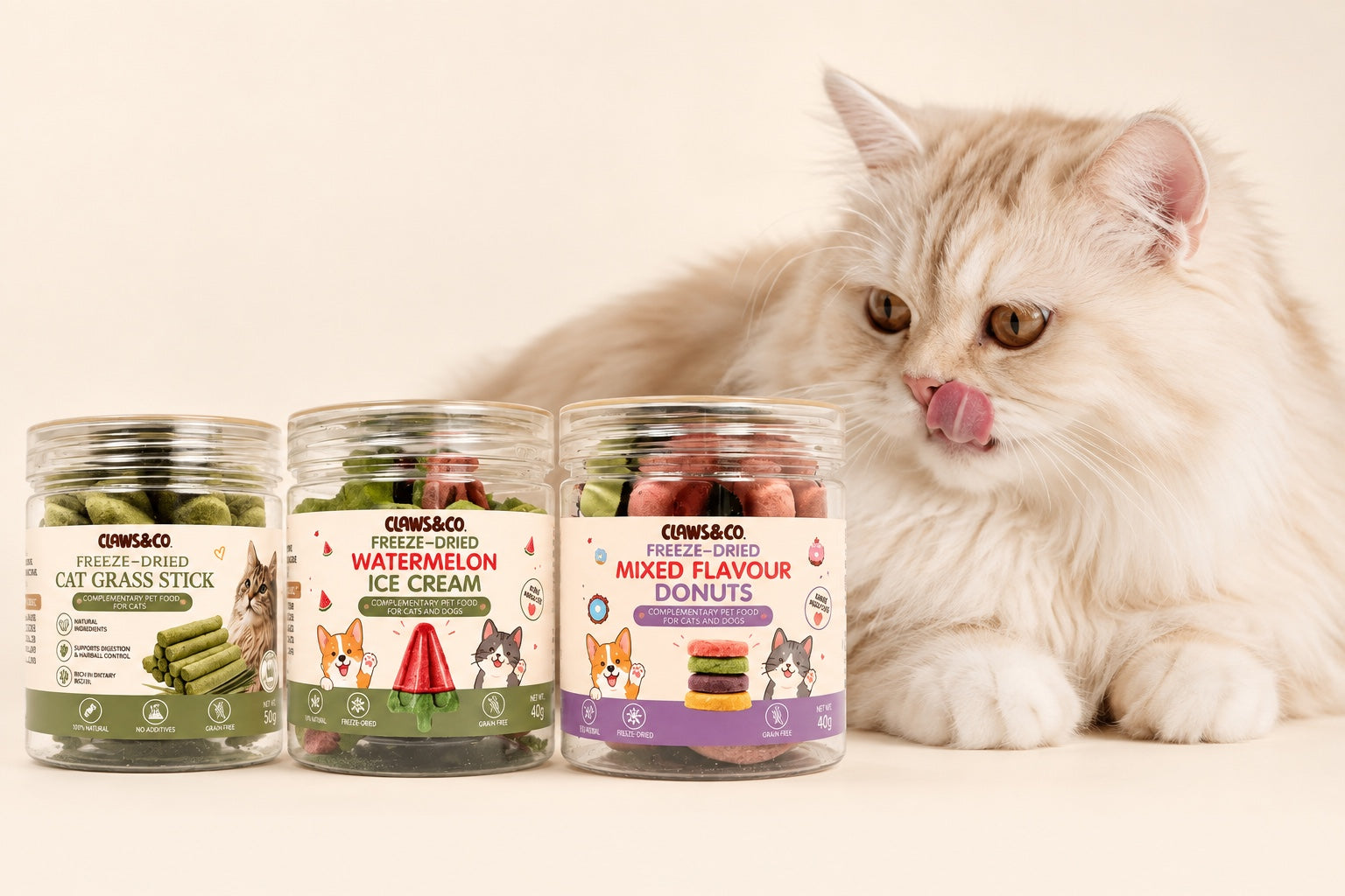 Fluffy cream cat licking its lips beside three Claws&Co treat jars
